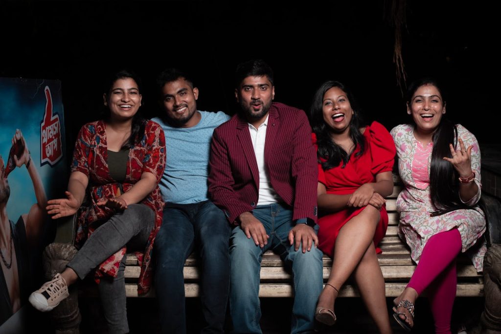 Five friends enjoying an evening on a bench, sharing laughter and good times.